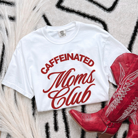 Flat lay of white Caffeinated Moms Club graphic tee — funny motherhood comfort colors shirt