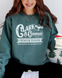 Woman wearing a Blue Spruce green Clark & Company Christmas sweatshirt while holding a festive holiday mug.