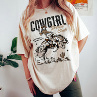 Model wearing Cowgirl Social Club tee in ivory — retro western graphic t-shirt for women