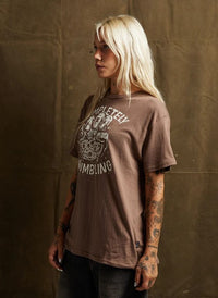 Woman in black jeans and vintage-style tee with crumbling cookie design. Pyknic brand unisex fit shirt for everyday wear.