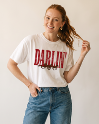 Woman wearing a white Darlin' Western horse tee with vintage distressed graphic and blue jeans.