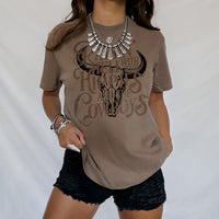 Model wearing espresso Raisin’ Hell tee — relaxed hippie cowgirl graphic shirt