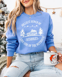 Woman wearing Carolina blue Jolliest Bunch of Assholes Christmas sweatshirt