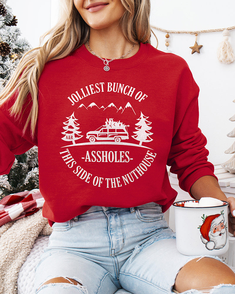 Woman wearing red Jolliest Bunch of Assholes Christmas crewneck sweatshirt