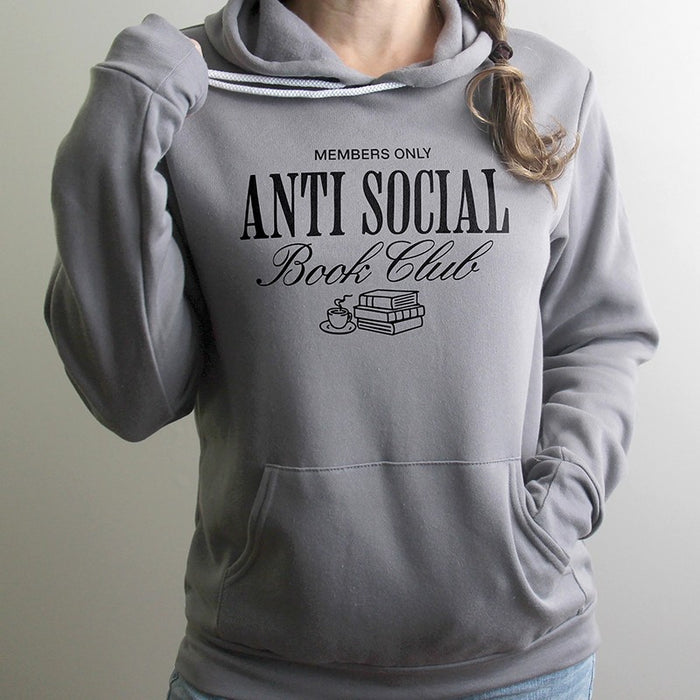 Woman wearing storm gray Antisocial Book Club hoodie with coffee mug – cozy reading sweatshirt for introverts and bookworms