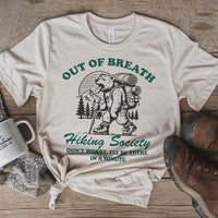 Flat lay of Out of Breath Hiking Society shirt — soft funny hiking tee in heather dust