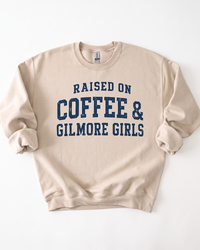 Sand Raised On Coffee & Gilmore Girls crewneck sweatshirt with distressed navy blue collegiate graphic lettering.