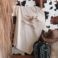 Flat lay of Riding With Purpose tee with western accessories — Christian cowgirl outfit inspiration