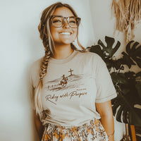 Model wearing Riding With Purpose tee in sand — western faith-based t-shirt for women