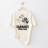 Flat lay of ivory tee back — slow living coffee shirt with hand-drawn snail design