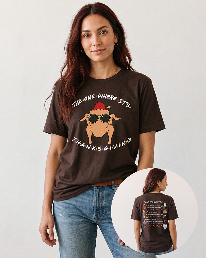 Brunette woman wearing a brown Friends-inspired Thanksgiving graphic tee with blue jeans, showing the turkey front print and Thanksgiving episode artwork on the back.