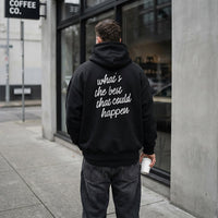 Male model wearing black What’s the Best That Could Happen hoodie with statement back print
