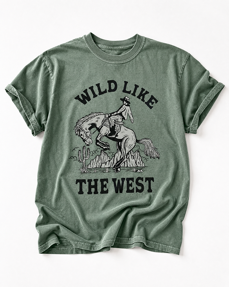 Sage Wild Like The West Western heavyweight tee featuring a cowboy on a bucking horse with desert scenery.