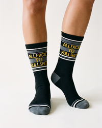 Close-up of black Allergic To Bullshit novelty crew socks with gray heels and toes
