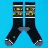 Pair of black Allergic To Bullshit gym socks with charcoal gray panels and yellow text