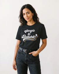 Woman wearing black Allergic to Bullshit retro graphic t-shirt with black jeans
