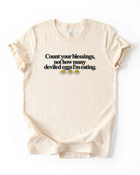 Natural cotton Thanksgiving graphic tee featuring the saying Count Your Blessings Not How Many Deviled Eggs I'm Eating.