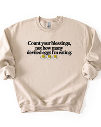Sand beige Thanksgiving graphic sweatshirt featuring the funny Count Your Blessings deviled eggs saying.