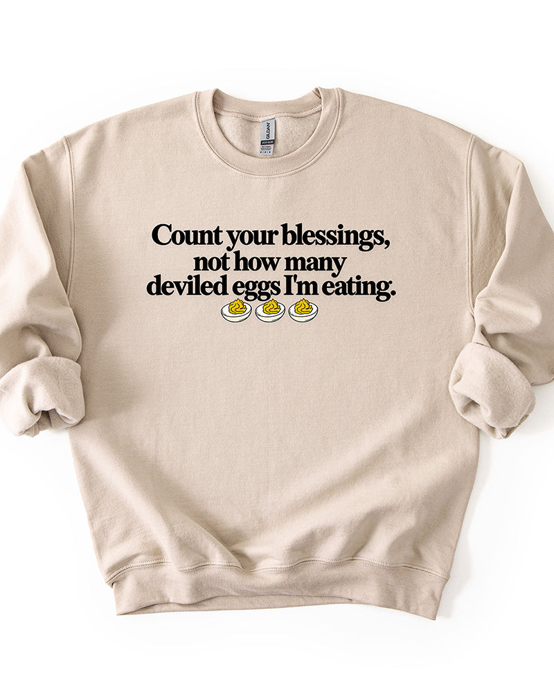 Sand beige Thanksgiving graphic sweatshirt featuring the funny Count Your Blessings deviled eggs saying.