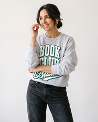 Woman wearing ash Book Club Baddie book lover sweatshirt