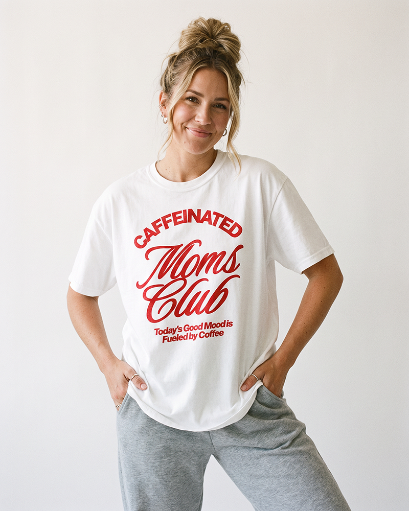 Mom wearing white Caffeinated Moms Club heavyweight tee with red retro graphic