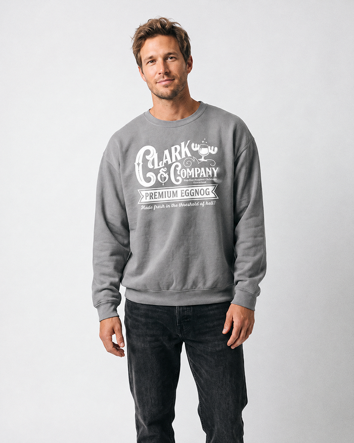 Man modeling a grey Clark Griswold-inspired Christmas graphic crewneck sweatshirt with dark jeans.