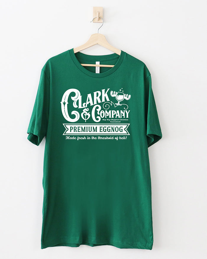 Evergreen green Clark & Company Premium Eggnog Christmas graphic tee with white vintage lettering and moose mug illustration.