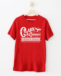 Red Clark & Company Premium Eggnog Christmas Vacation inspired tee featuring a white retro holiday graphic.