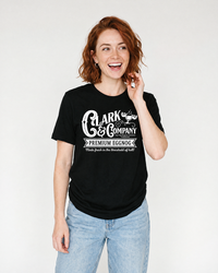 Woman modeling a black Clark Griswold-inspired eggnog Christmas graphic tee with blue jeans.