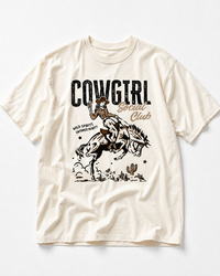Ivory Cowgirl Social Club heavyweight tee featuring cowgirl and bucking bronco Western artwork.
