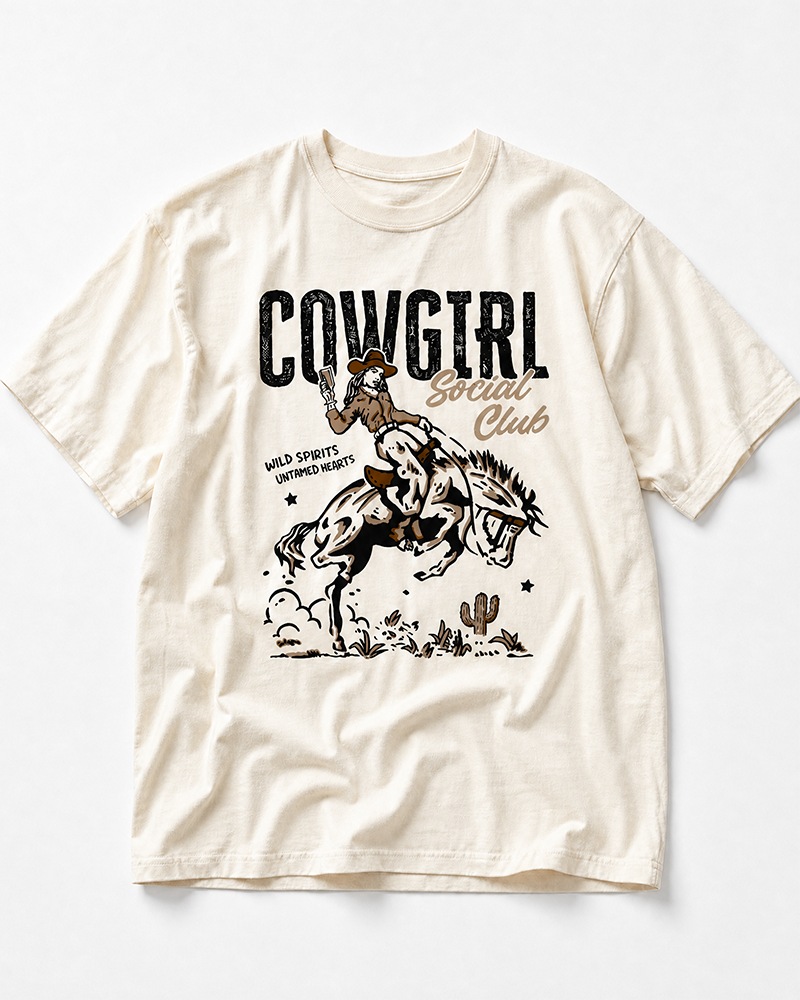 Ivory Cowgirl Social Club heavyweight tee featuring cowgirl and bucking bronco Western artwork.