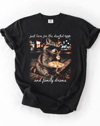 Black Comfort Colors heavyweight tee with funny raccoon and deviled eggs artwork and white family drama script lettering.