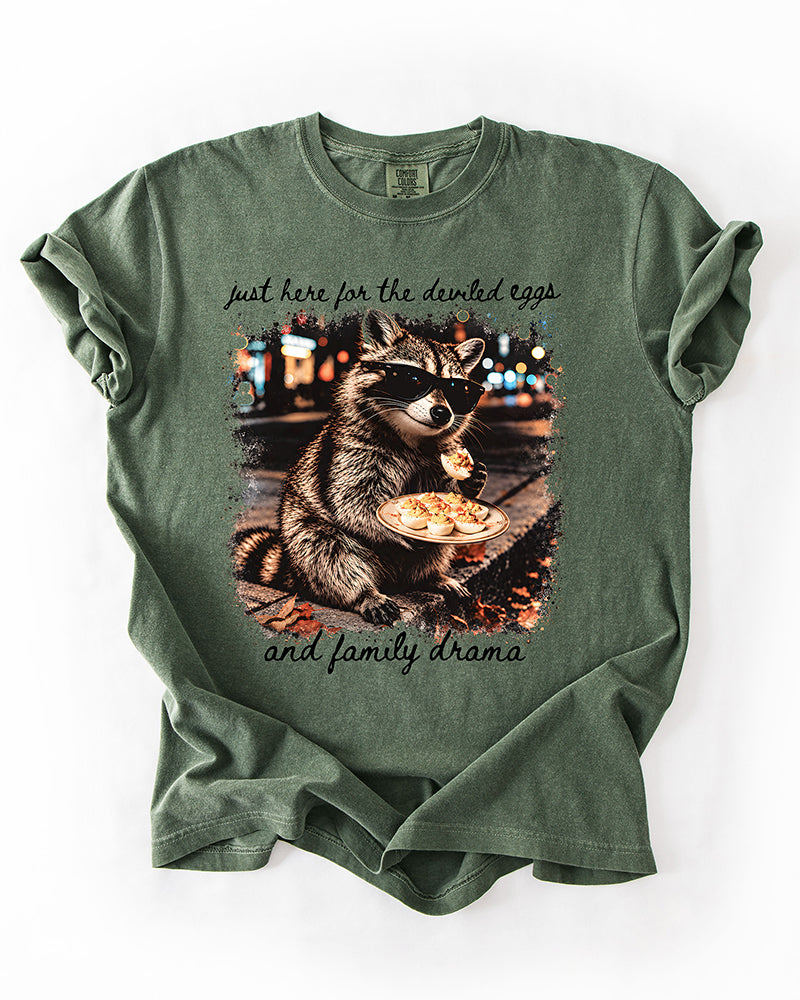 Hemp green Comfort Colors tee with funny Thanksgiving raccoon graphic, deviled eggs illustration, and black script lettering.