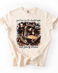 Ivory Comfort Colors heavyweight tee featuring a raccoon with deviled eggs and black Just Here for the Deviled Eggs and Family Drama script.