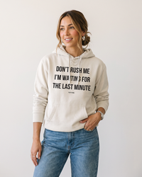 Woman wearing Ivory Don't Rush Me funny graphic hoodie with black lettering