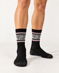 Female model wearing black Everything Hurts and I'm Dying crew grip socks for Pilates