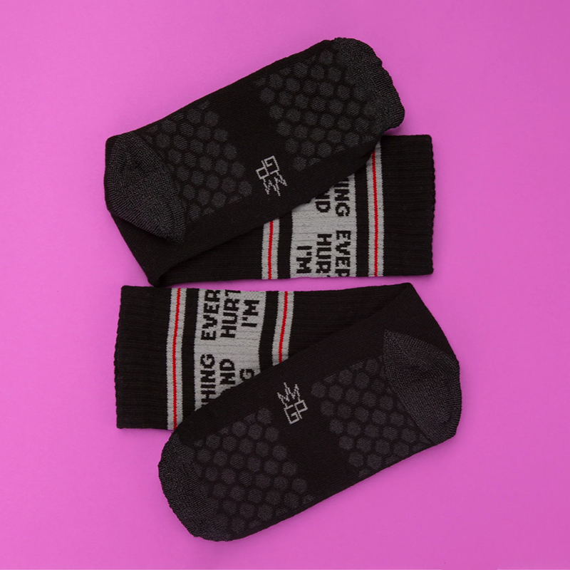 Bottom of black Pilates grip socks showing woven-in non-slip hexagon grip pattern