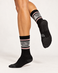 Everything Hurts and I'm Dying Pilates socks showing black non-slip grip soles on female model