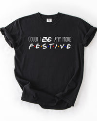 Black heavyweight Christmas graphic tee featuring Could I BE Any More Festive typography with colorful Friends-inspired dots.