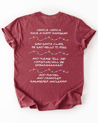 Back of brick red Friends Christmas T-shirt featuring nostalgic holiday song lyrics and illustrated strands of colorful Christmas lights.