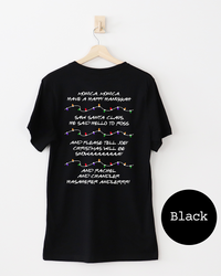 Back of black Christmas graphic tee featuring memorable Friends holiday quotes and colorful illustrated Christmas light strands.