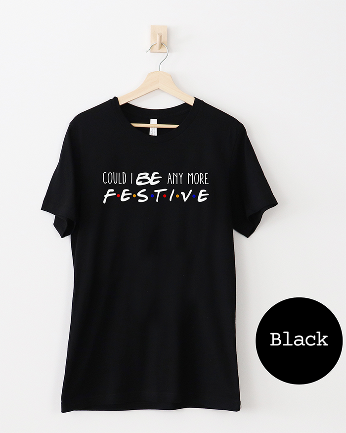 Black Friends-inspired Christmas lightweight tee with Could I BE Any More Festive graphic in white lettering and colorful dots.