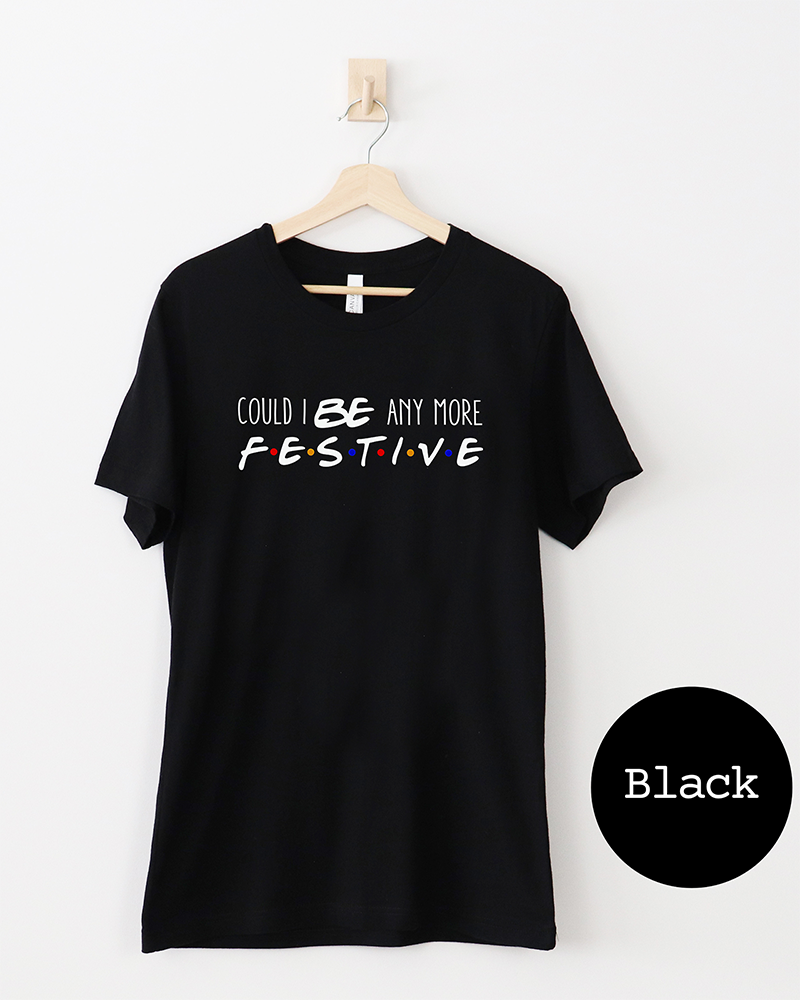 Black Friends-inspired Christmas lightweight tee with Could I BE Any More Festive graphic in white lettering and colorful dots.