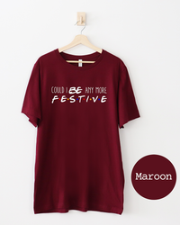 Maroon Could I Be Any More Festive lightweight tee featuring white Friends-inspired typography with colorful dots.