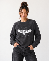 Woman wearing Free Spirit graphic raglan sweatshirt with black jeans