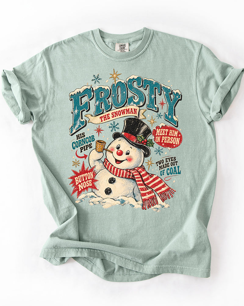Bay green Comfort Colors heavyweight Christmas T-shirt with large vintage Frosty the Snowman illustration, teal lettering, red scarf, and distressed details.