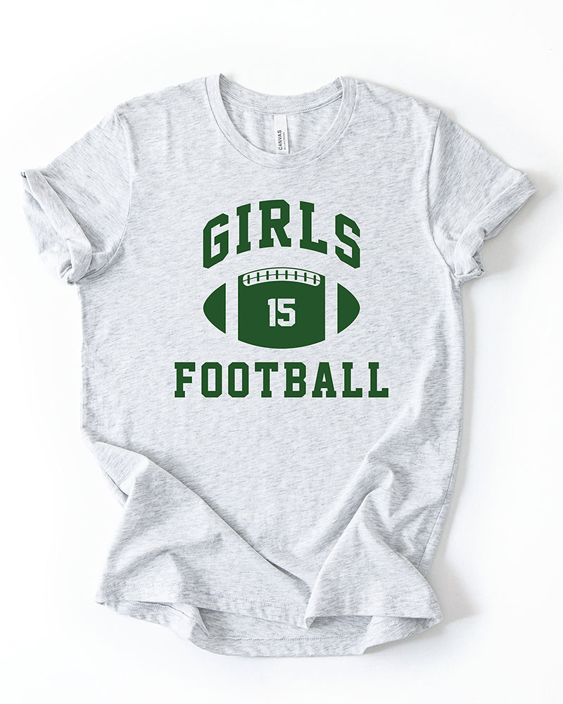 Ash grey lightweight Girls Football graphic tee featuring green varsity lettering and a football with number 15.