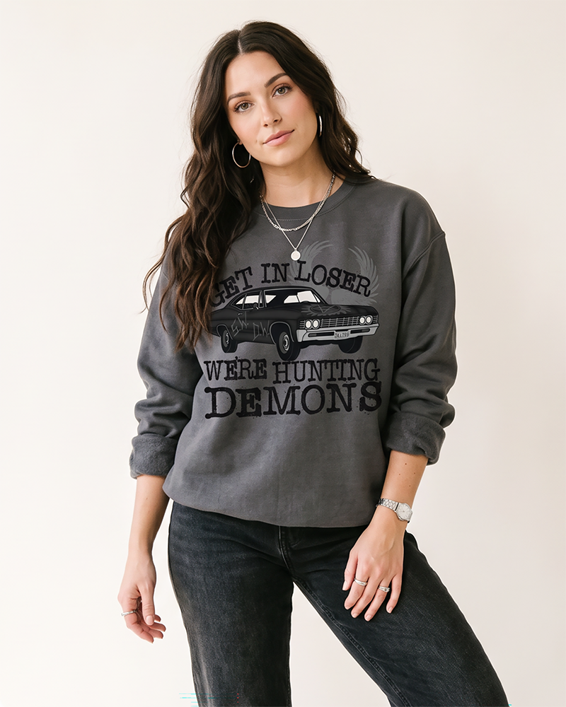 Charcoal Get In Loser We're Hunting Demons graphic sweatshirt on female model