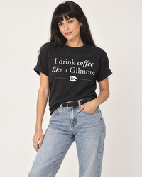 Woman wearing black I Drink Coffee Like a Gilmore graphic tee