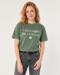Woman wearing moss green I Drink Coffee Like a Gilmore graphic tee